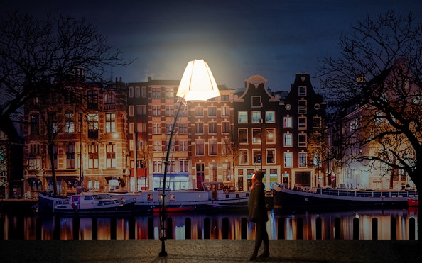 Amsterdam Light Festival installation with canal houses and boats at night.