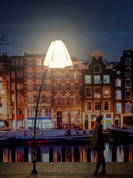 Amsterdam Light Festival installation with canal houses and boats at night.