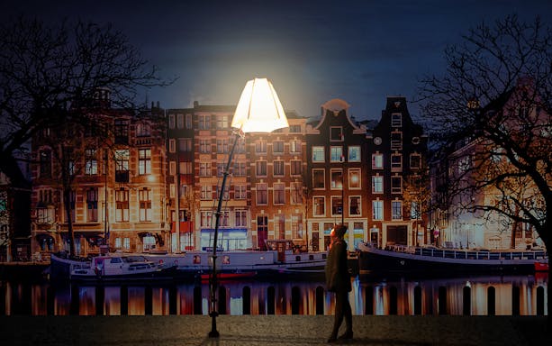 Amsterdam Light Festival installation with canal houses and boats at night.