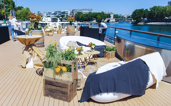Seine River cruise deck with seating and floral decor for Le Diamant Bleu dinner experience.