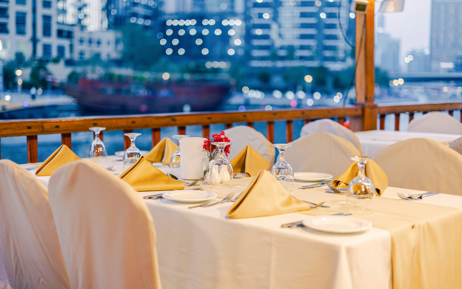 Dining setup on a dhow cruise with city skyline in the background.