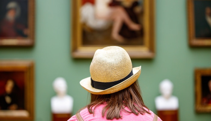 Visitor observing artwork at the Louvre Museum, Paris.