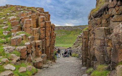 Visitors walking through basalt columns at Giant's Causeway, Northern Ireland.