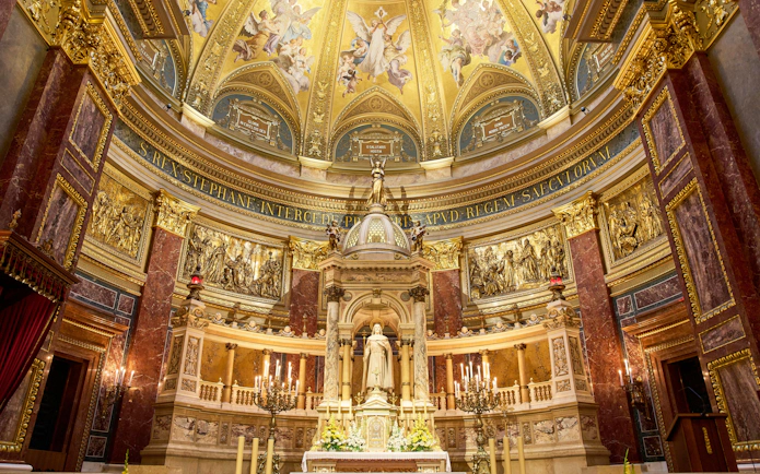 Altar in St. Stephen's Basilica, Budapest, featuring ornate gold detailing and religious statues.