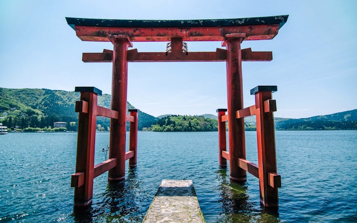 Torii gate at Lake Ashi with mountains in the background, Japan.