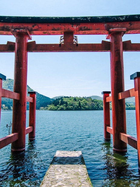 Torii gate at Lake Ashi with mountains in the background, Japan.