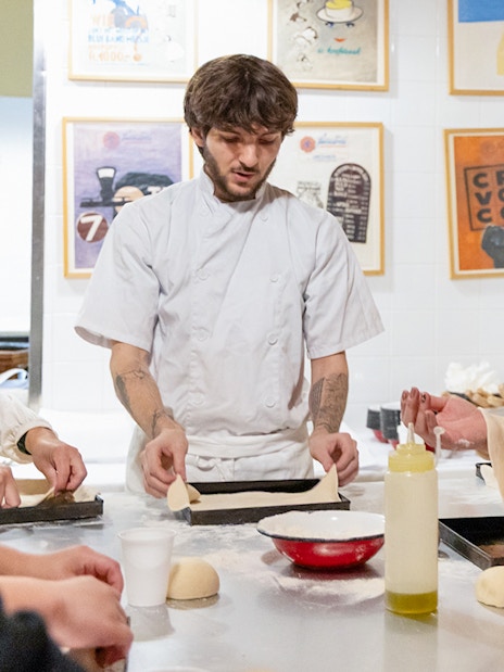 Participants making pizza dough in a Rome kitchen cooking class.