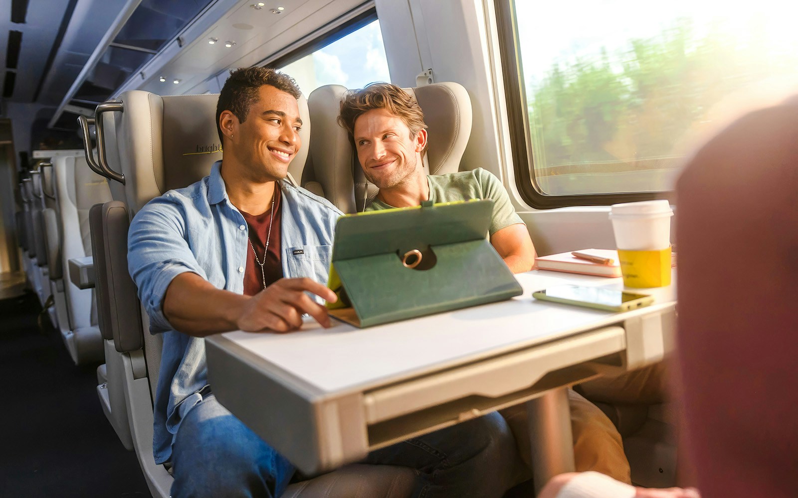 Passengers enjoying a tablet on the Brightline train from Miami to Orlando.