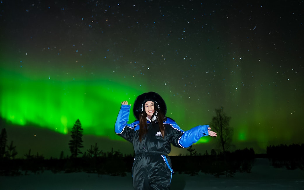 Person enjoying Northern Lights display in Levi, Finland.