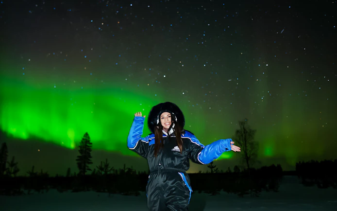 Person enjoying Northern Lights display in Levi, Finland.