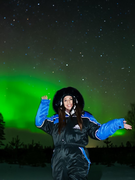 Person enjoying Northern Lights display in Levi, Finland.