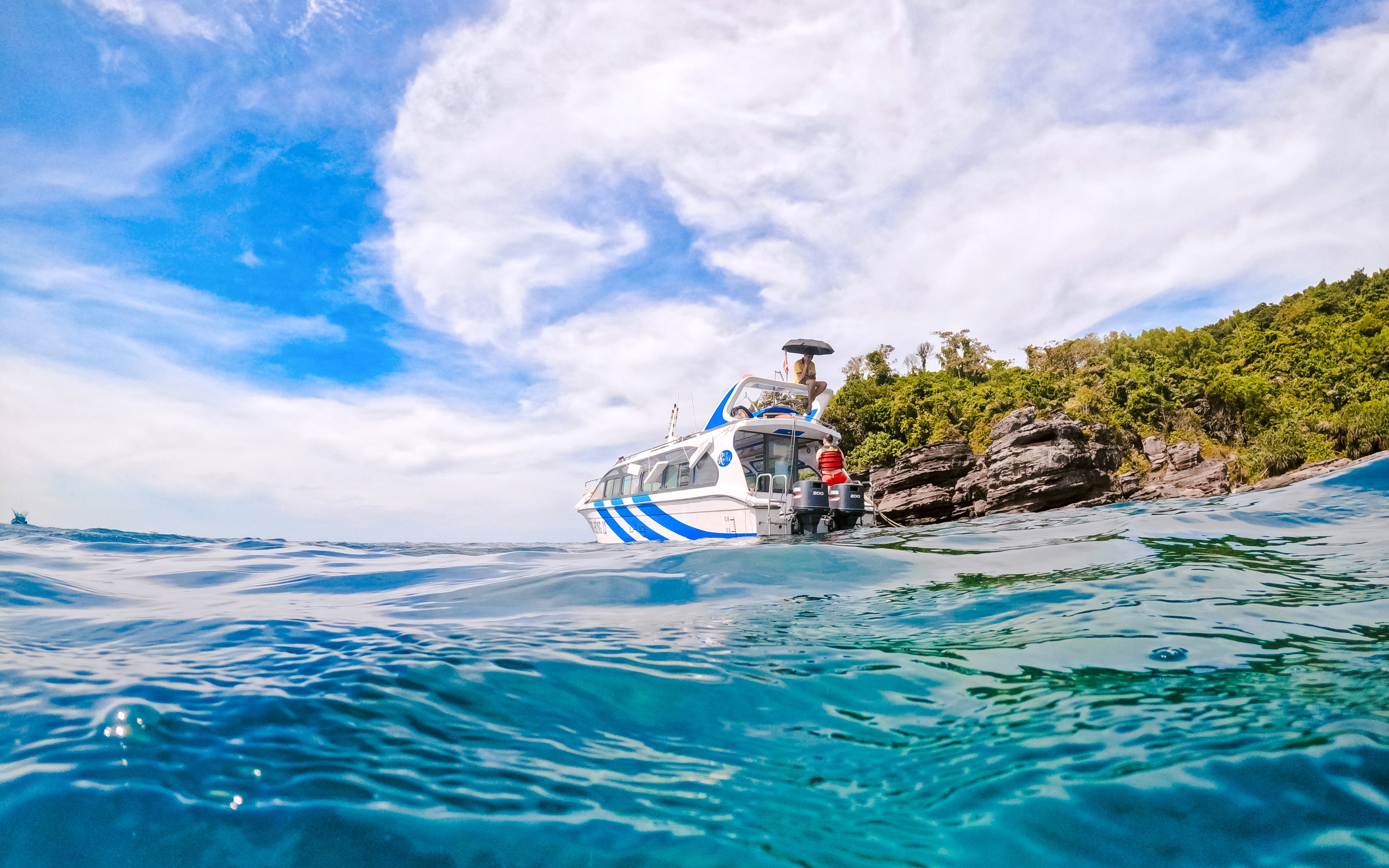 Speed boat near rocky shore on Phu Quoc 3 Island Hopping Tour.