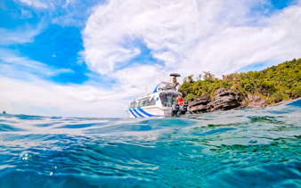 Speed boat near rocky shore on Phu Quoc 3 Island Hopping Tour.