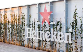 Heineken logo on rooftop with ivy-covered wall, Amsterdam experience.