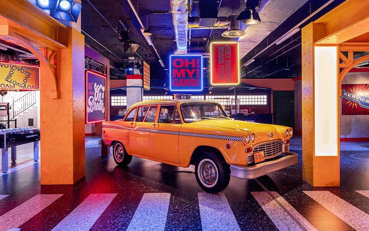 Yellow taxi inside Central Perk replica at The FRIENDS VIP Experience in London.
