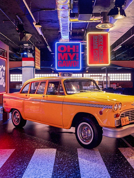 Yellow taxi inside Central Perk replica at The FRIENDS VIP Experience in London.