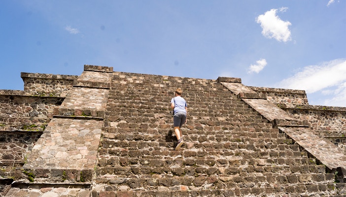 Tourist climbing the Pyramid of the Moon in Teotihuacan, Mexico.