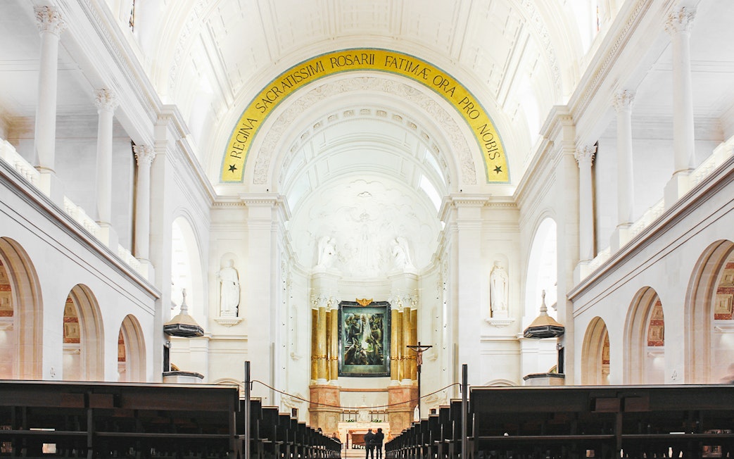Interior of Fatima Christian Sanctuary in Portugal with altar and arches.