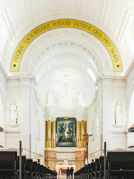 Interior of Fatima Christian Sanctuary in Portugal with altar and arches.