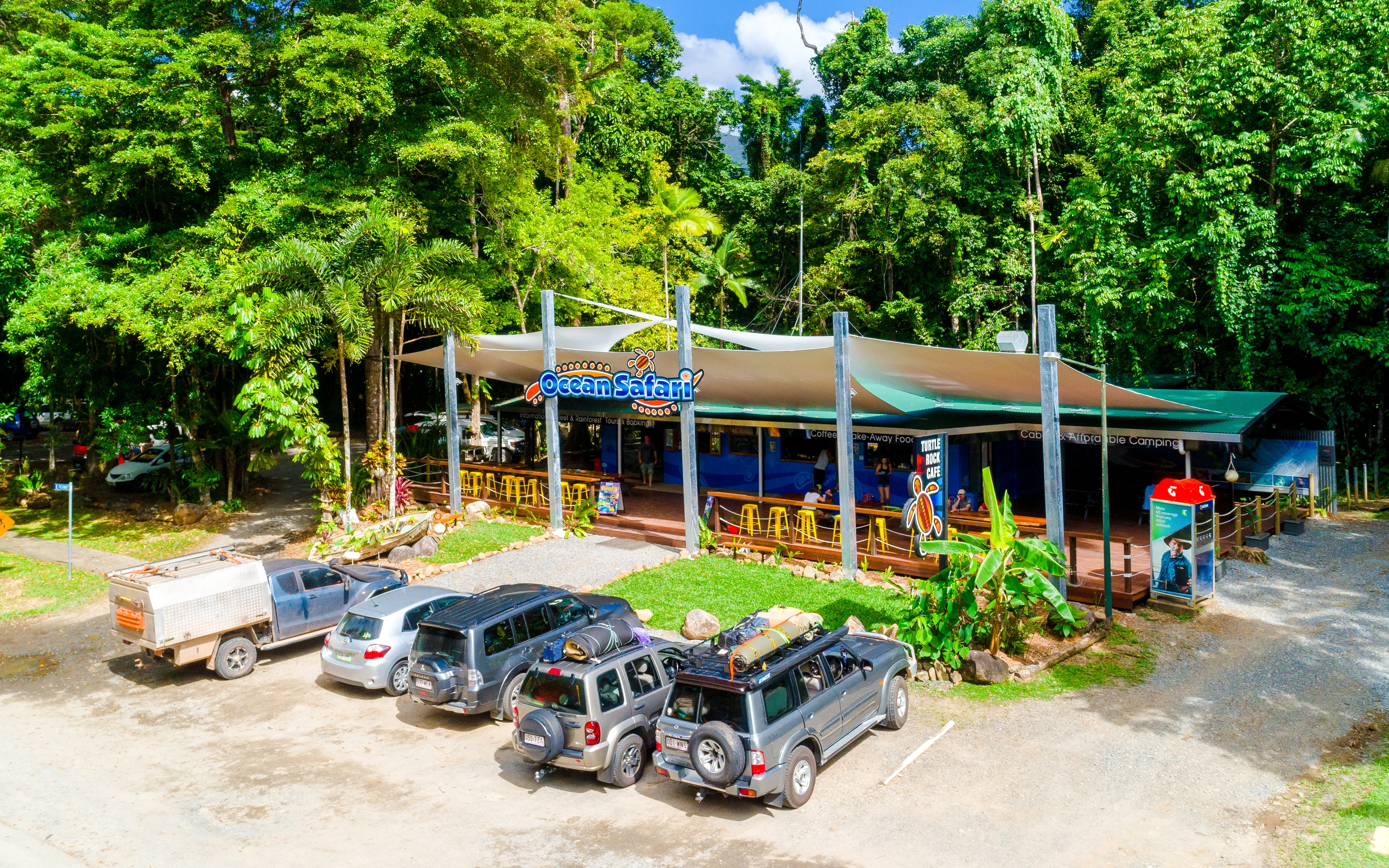 Ocean Safari tour base near Great Barrier Reef with parked vehicles and lush greenery.