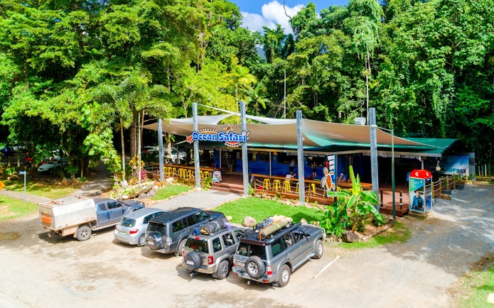 Ocean Safari tour base near Great Barrier Reef with parked vehicles and lush greenery.
