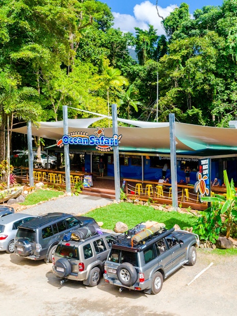 Ocean Safari tour base near Great Barrier Reef with parked vehicles and lush greenery.