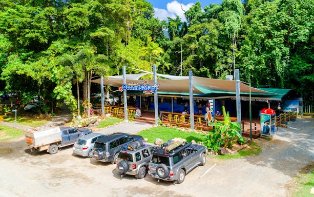 Ocean Safari tour base near Great Barrier Reef with parked vehicles and lush greenery.