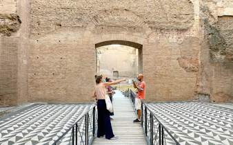 Visitors exploring the ancient ruins of the Baths of Caracalla in Rome.