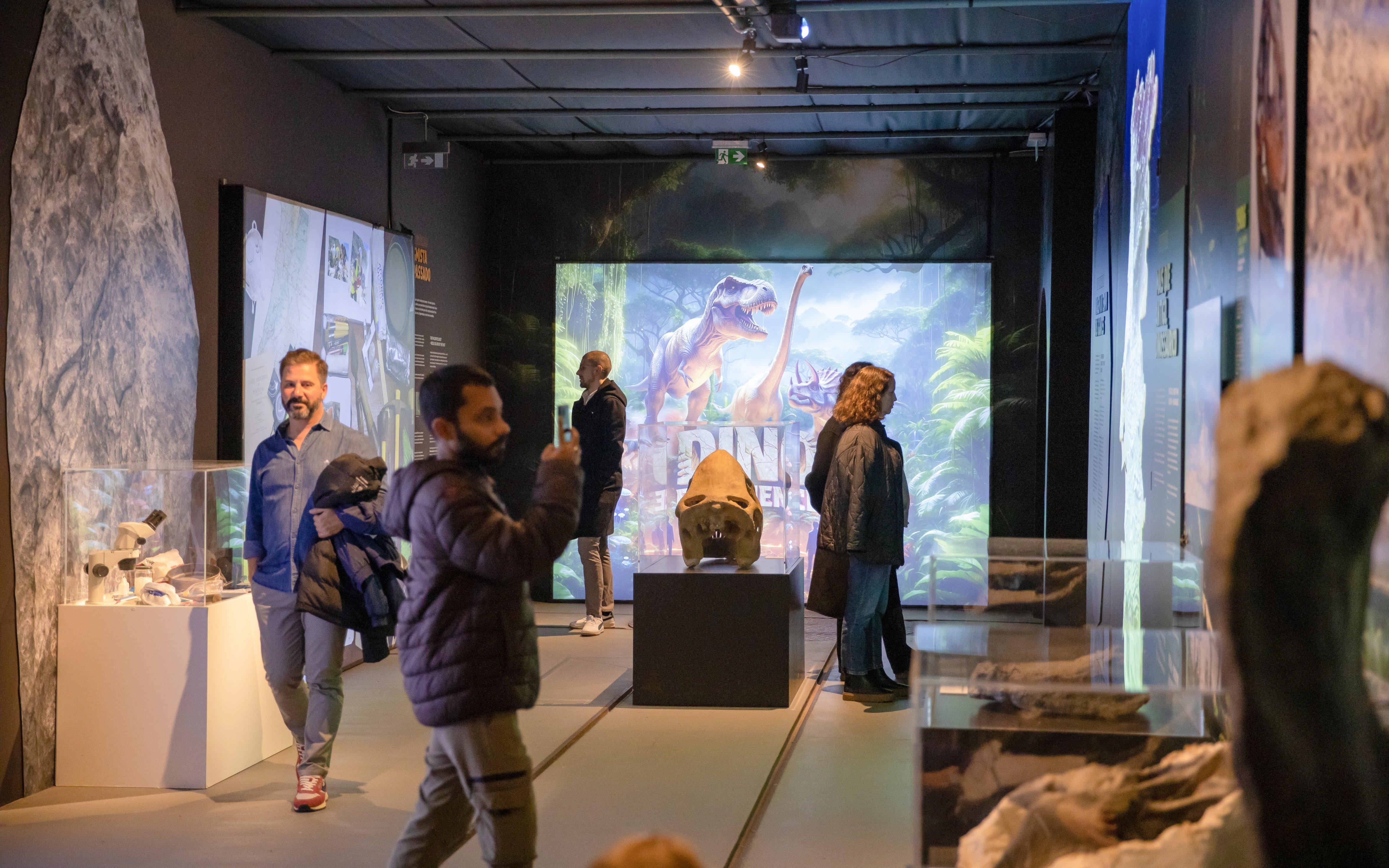 Interior exhibits of Immersive Dinosaur Exhibition at Dino Experience Porto with visitors exploring displays.