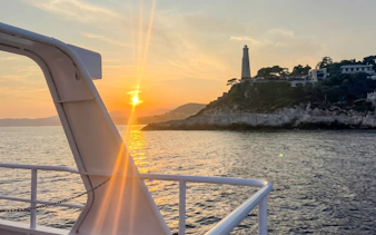 Sunset view from a boat near Villefranche lighthouse on a coastal tour.