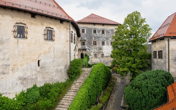 Inner courtyard of Bled Castle in Slovenia with stone path and greenery.