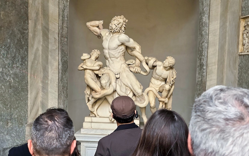 Visitors viewing Laocoön and His Sons sculpture at Vatican Museums.