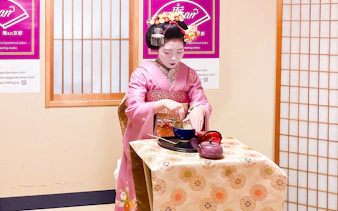 Maiko performing tea ceremony in traditional attire during cultural experience in Kyoto.