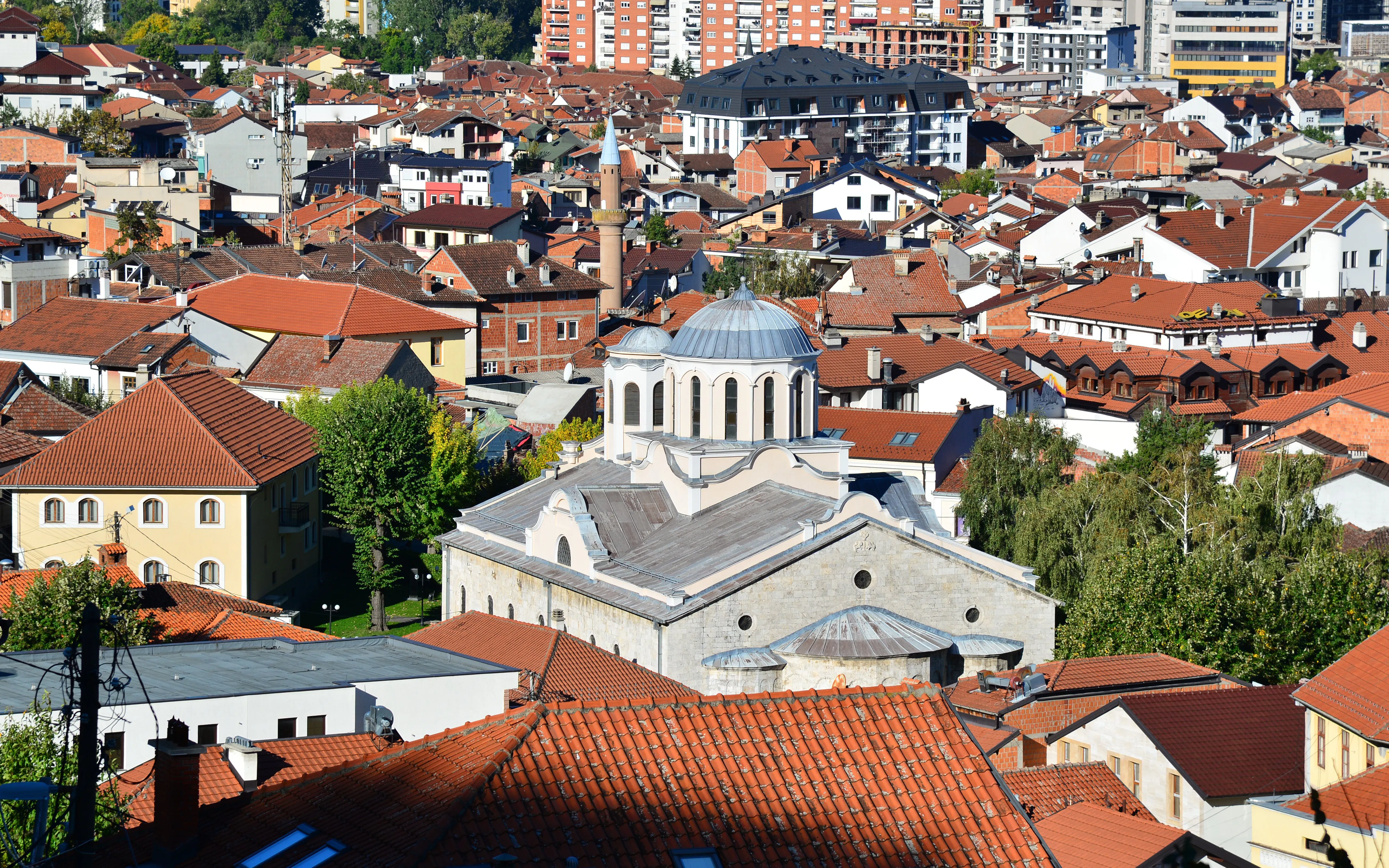 Cathedral of St. George in Prizren surrounded by red-roofed buildings.