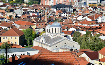 Cathedral of St. George in Prizren surrounded by red-roofed buildings.
