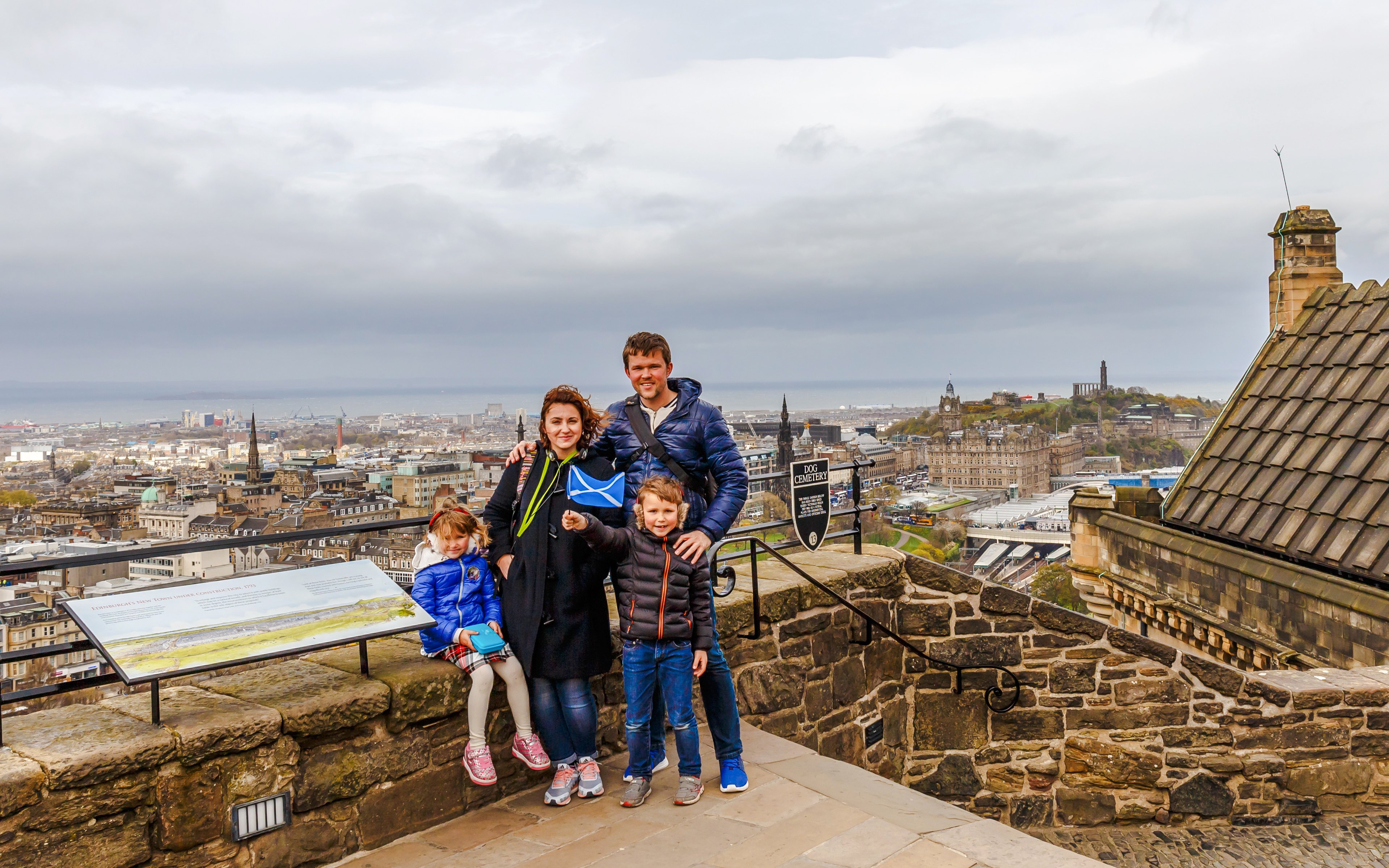 Family enjoying the view from Edinburgh Castle overlooking the cityscape.