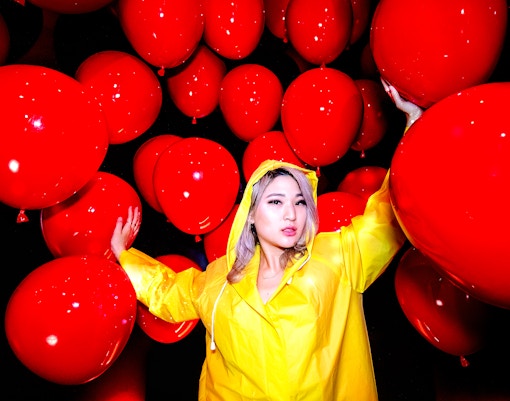 Guest in yellow raincoat surrounded by red balloons at Madame Tussauds Hollywood.