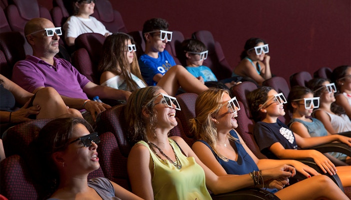 Visitors enjoying 4D cinema experience at Isla Magica theme park, Seville, Spain.
