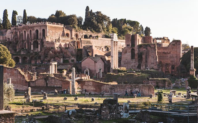 Ancient ruins of Villa Jovis on Capri, Italy, with tourists exploring the site.
