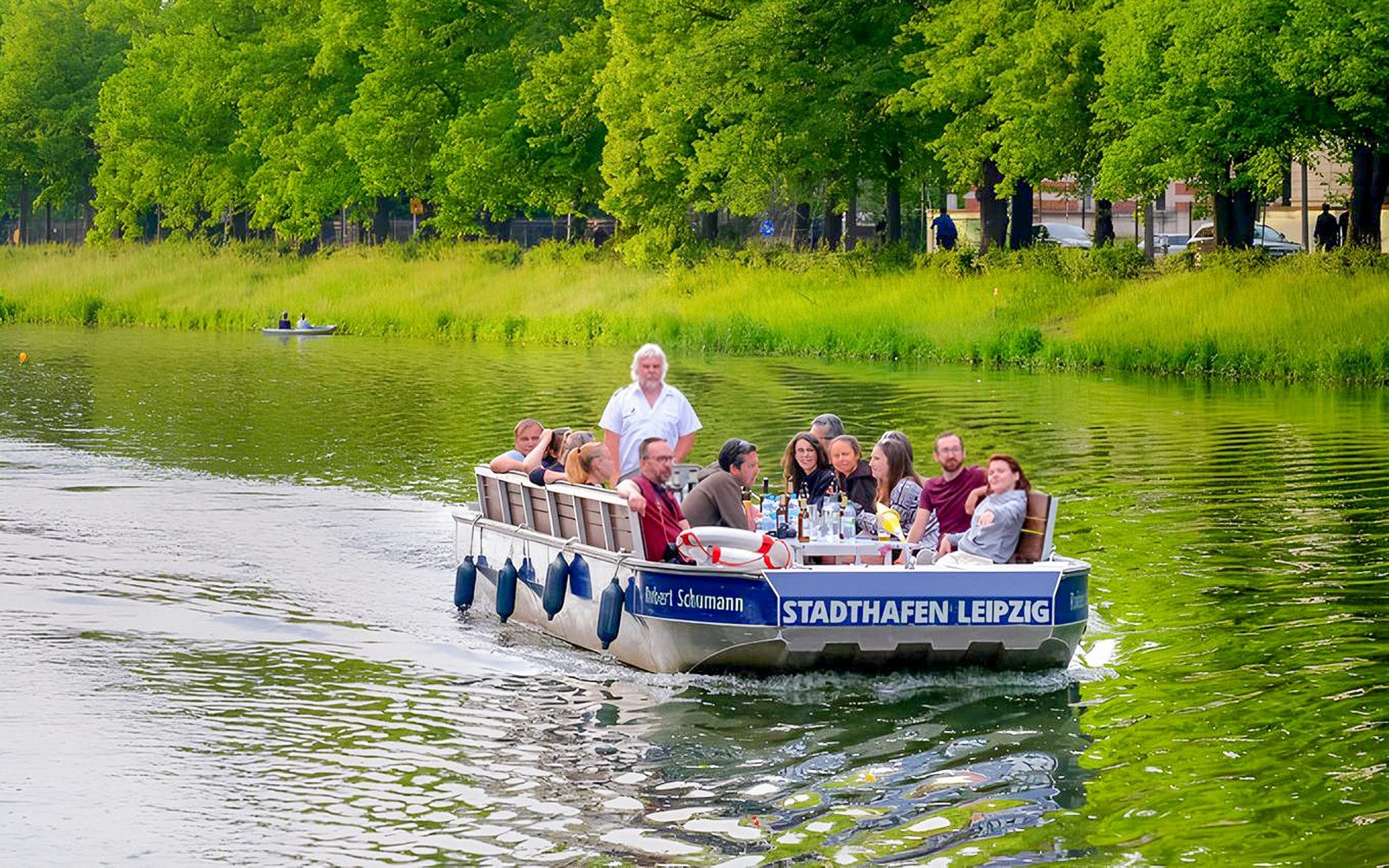 Guests on a motorboat tour navigating Auwald forest waterways in Leipzig.