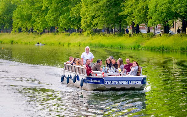 Guests on a motorboat tour in Auwald, Leipzig, enjoying the scenic river view.