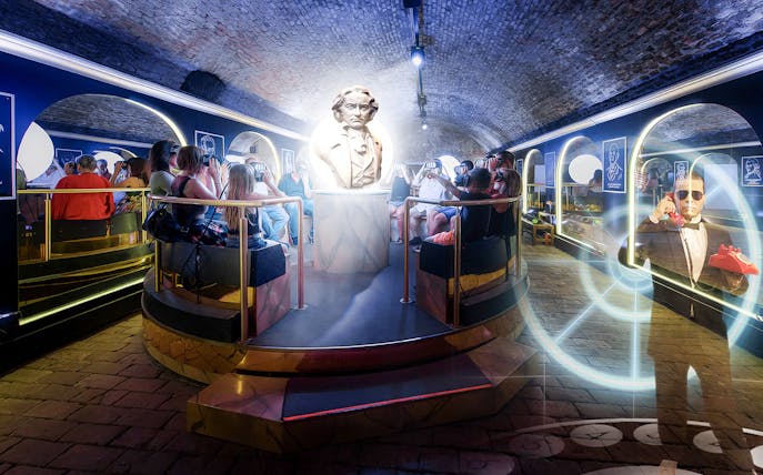 Visitors using VR headsets in Time Travel Vienna's history installation with a central statue.