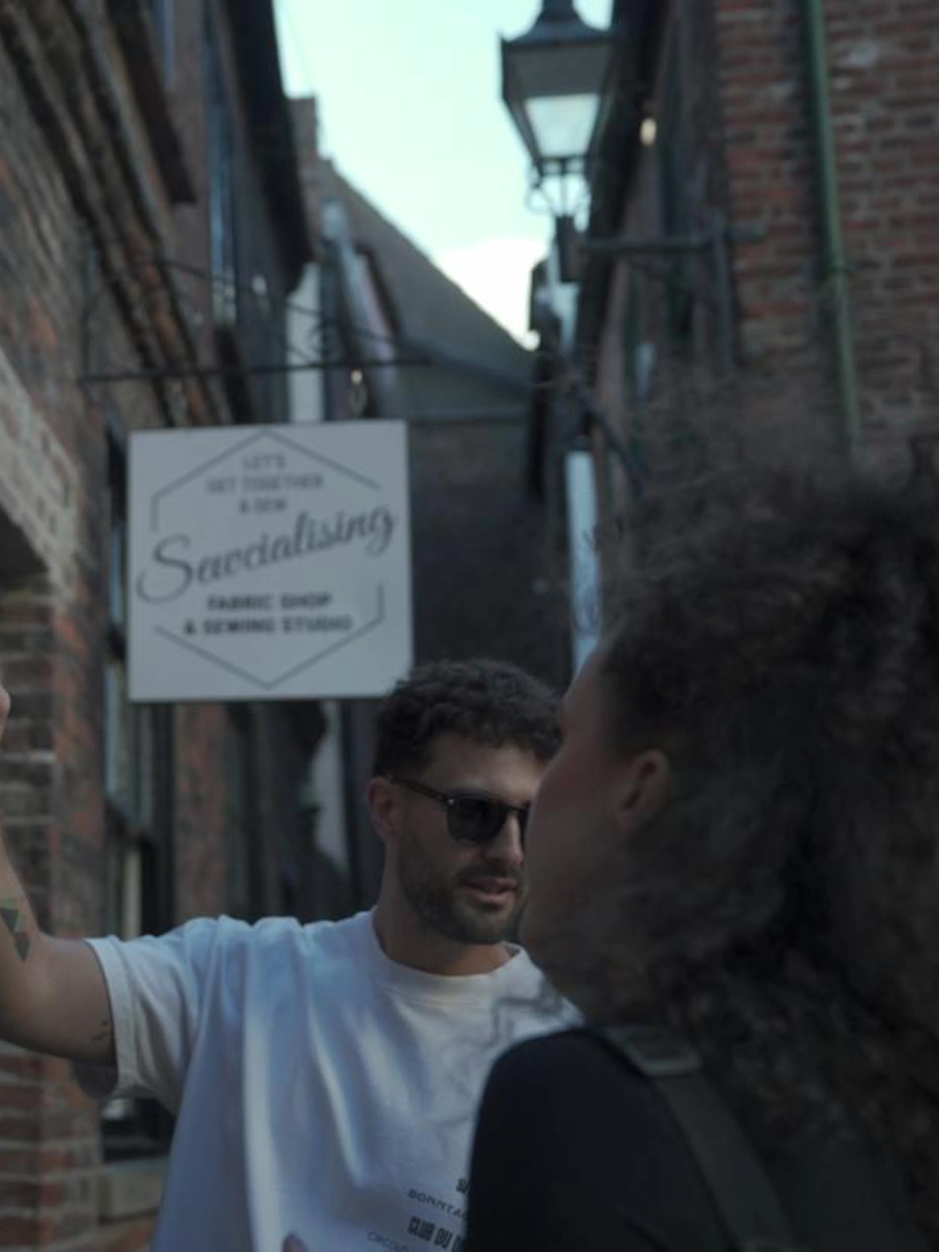 Man pointing at a clue on a brick wall during York outdoor escape room adventure game.