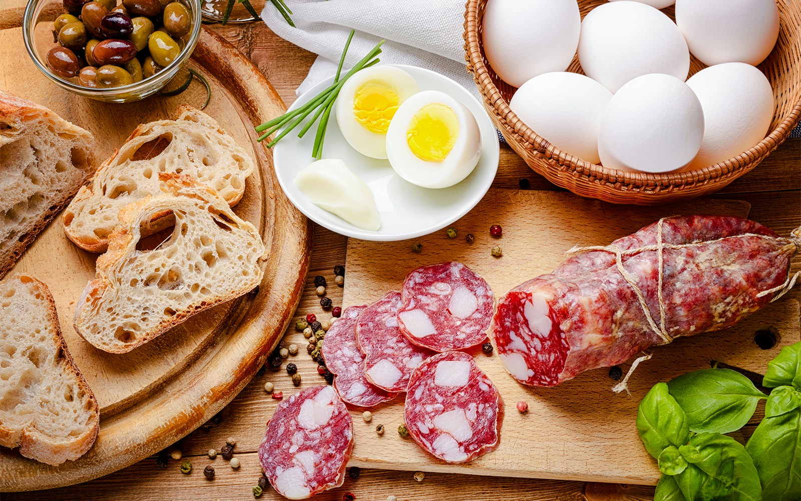 Boiled egg and coral salami on a white plate.