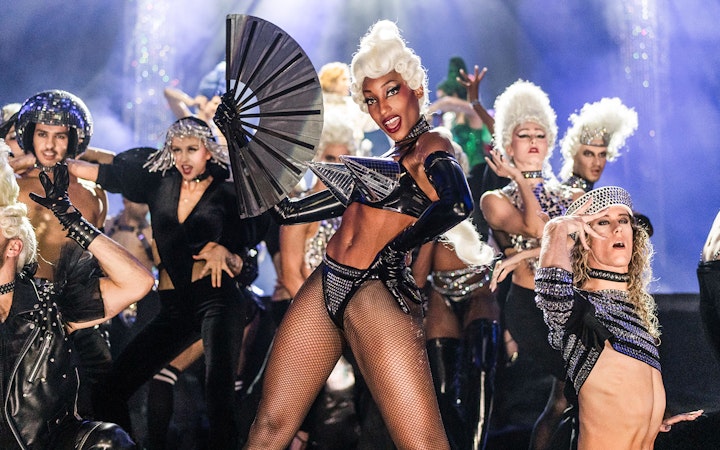 Performers in elaborate costumes on stage at FALLING | IN LOVE Grand Show.