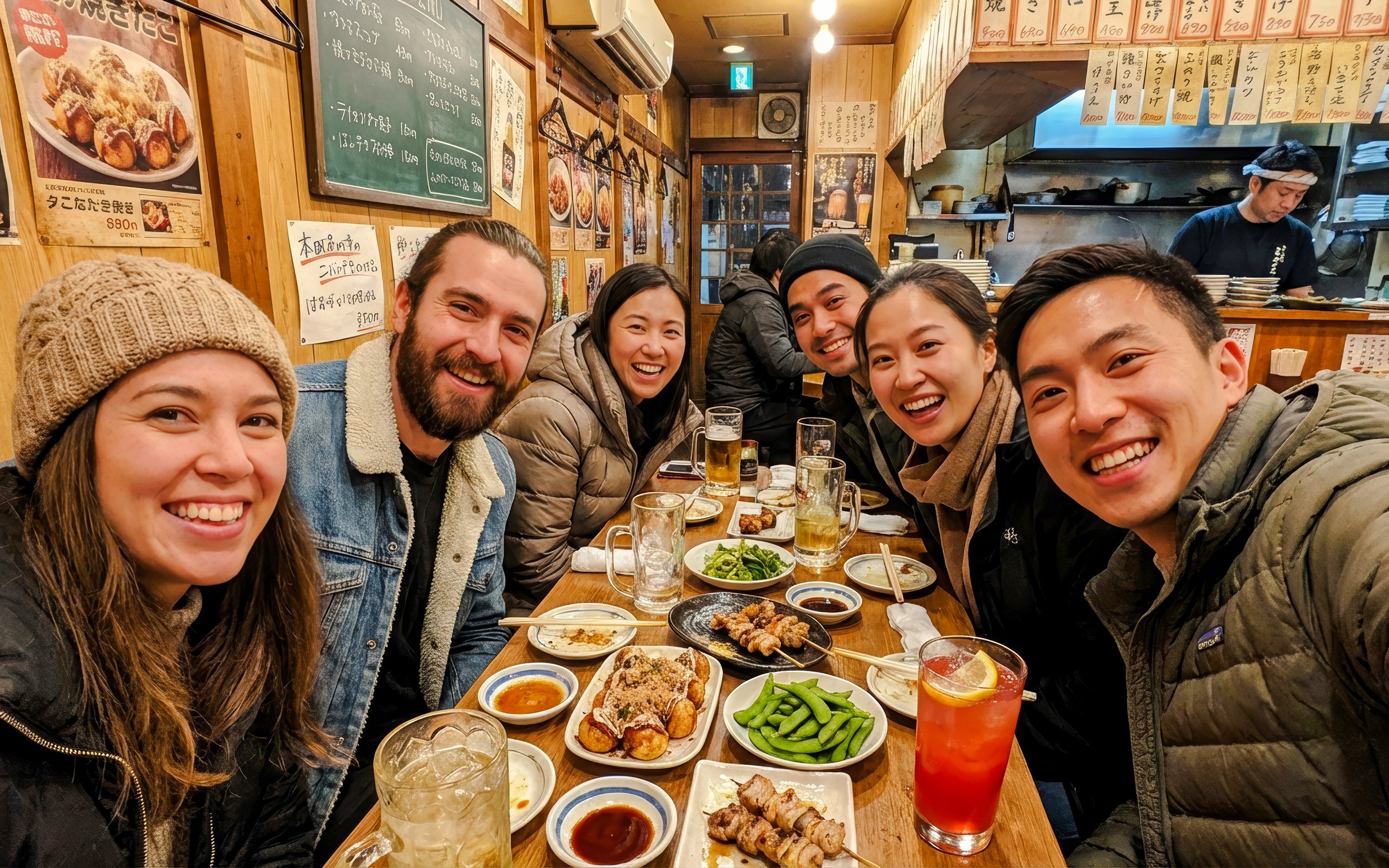 Group enjoying food and drinks at an Osaka eatery during a food tour.