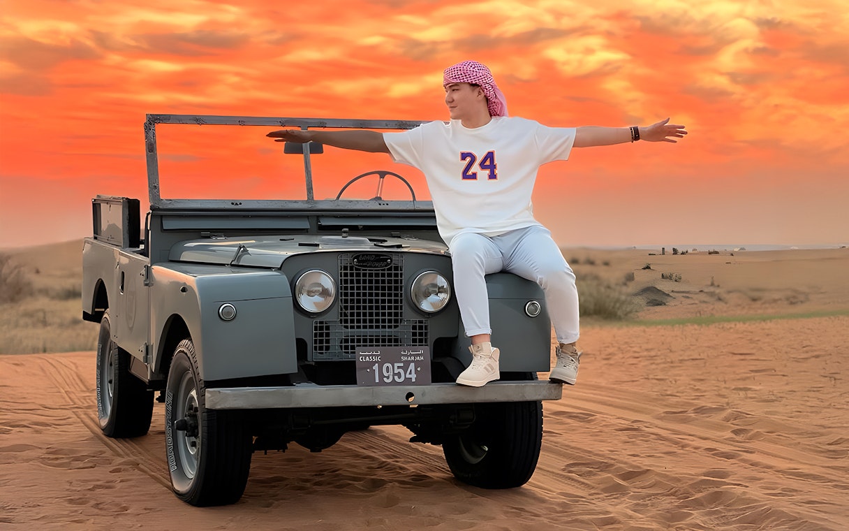 Vintage Land Rover in desert at sunset, part of hot air balloon experience.