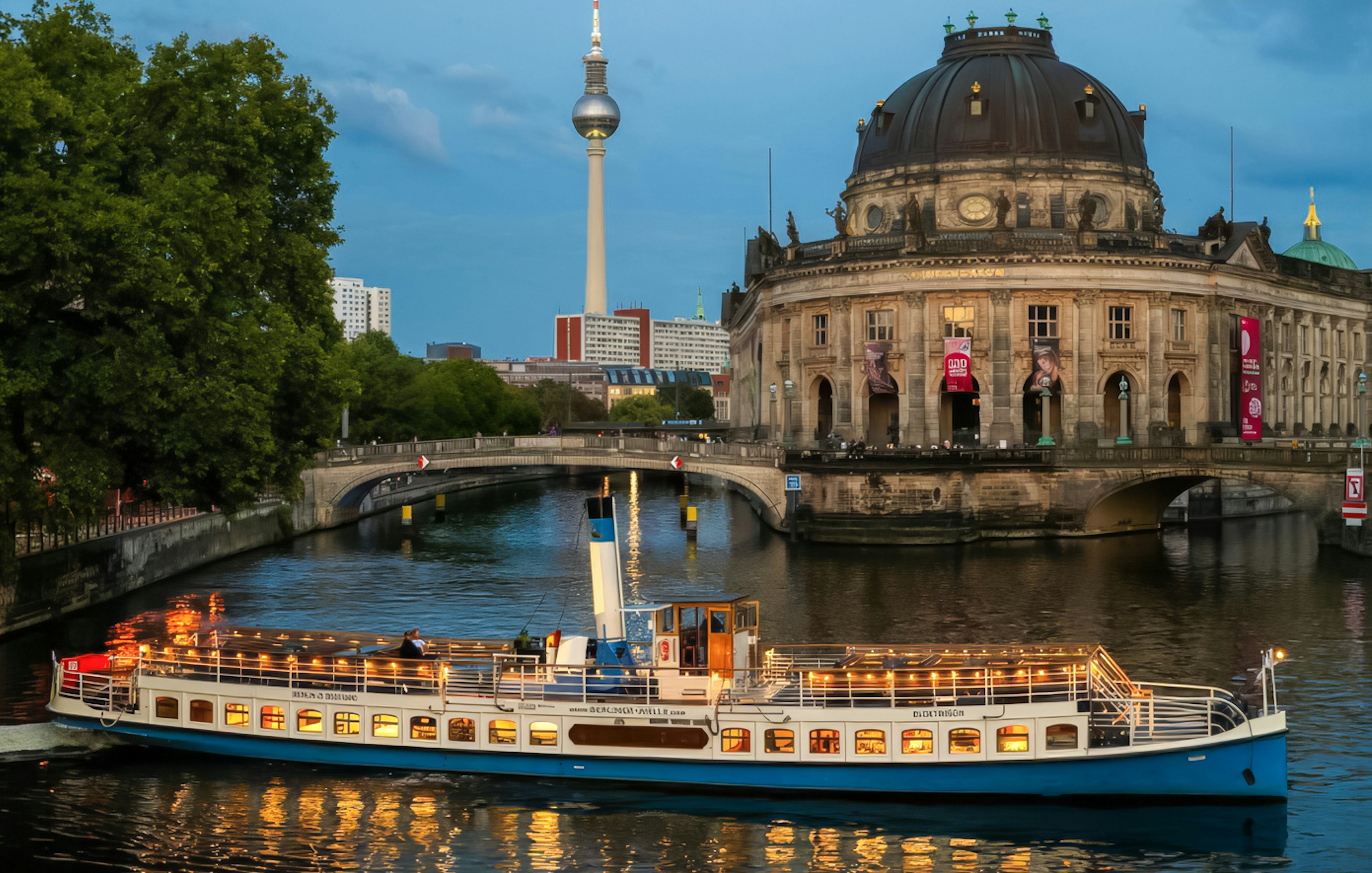 Evening cruise boat passing Bode Museum on Museum Island, Berlin, with TV Tower in background.