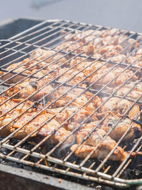 Barbeque chicken grilling on deck during Great Barrier Reef cruise with ocean view.