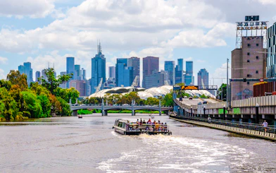 Cruise boat on Yarra River with Melbourne skyline in the background.